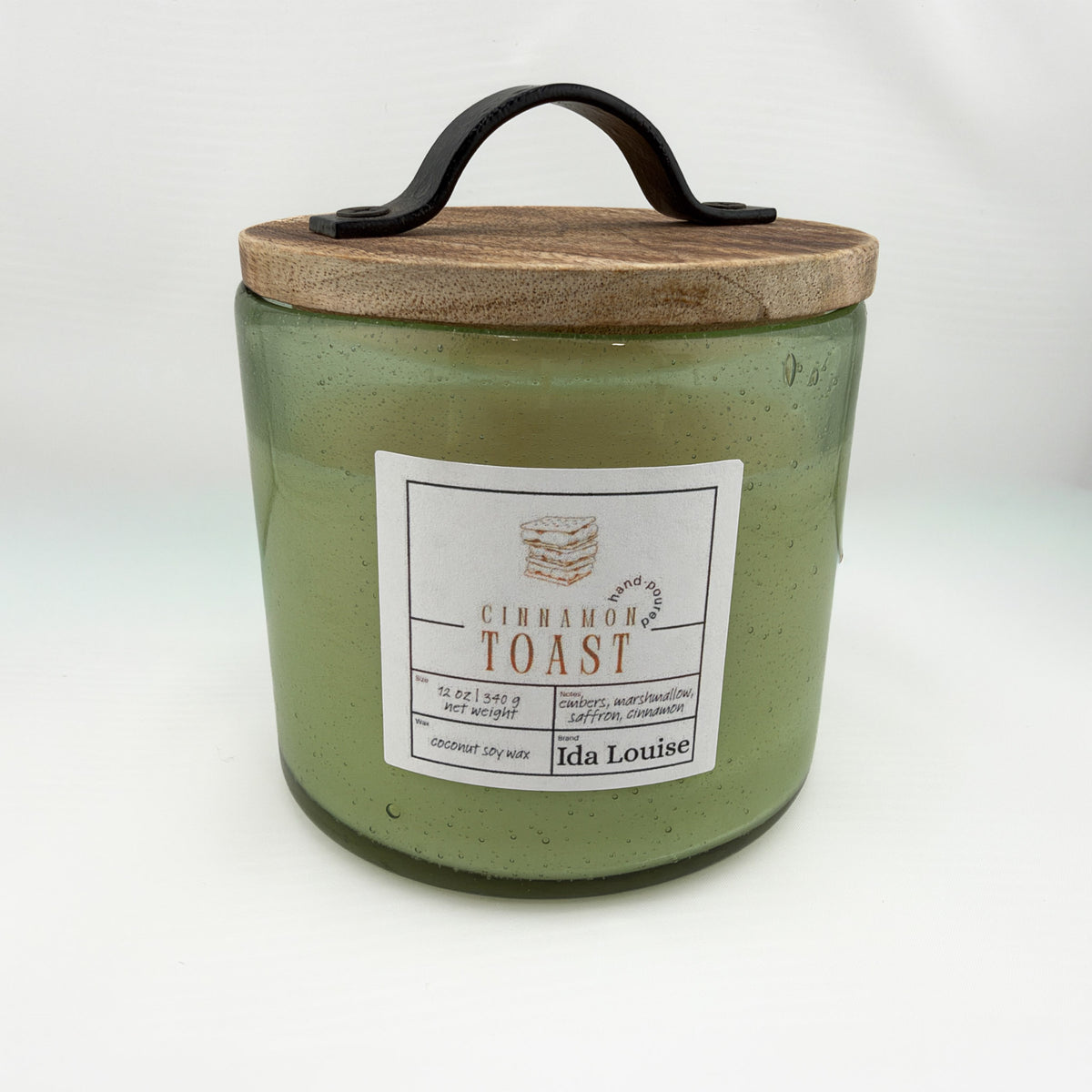 Ida Louise Cinnamon Toast candle in a green bubble-glass jar with a wooden lid and leather handle
